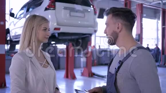 专业维修汽车技师拿着钥匙和女客户握手然后微笑着看着摄像机视频的预览图