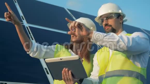 一位女性和一位男性能源工作者正在讨论建设项目并指出了不同的方向视频的预览图