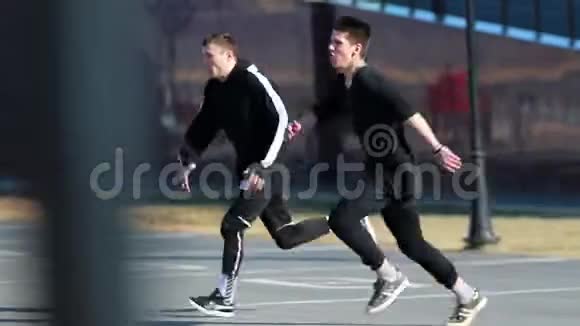 两个年轻的运动员克服障碍表演跑酷技巧视频的预览图