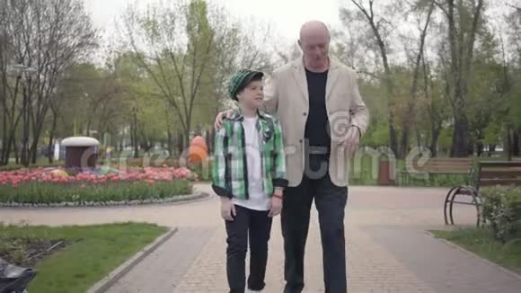 肖像可爱的祖父和可爱的孙子走在公园的镜头世代概念友好家庭视频的预览图