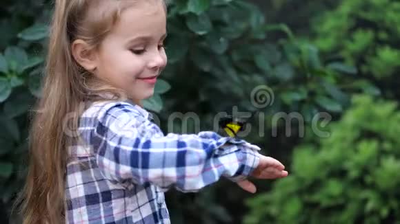 一个女孩手里拿着一只蝴蝶微笑着蝴蝶飞走了女孩看起来很惊讶4K慢慢视频的预览图