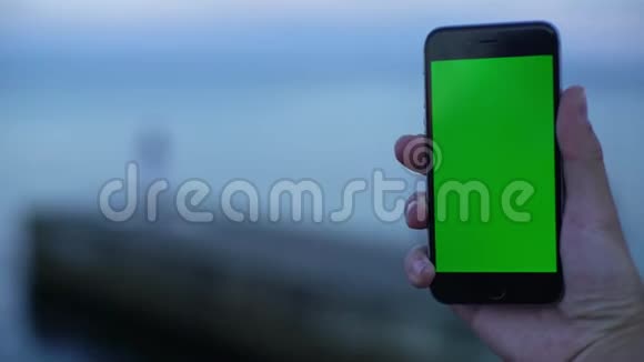 智能手机的概念视图与绿色屏幕彩色跟踪哑光在海滨防波堤码头削减美丽视频的预览图