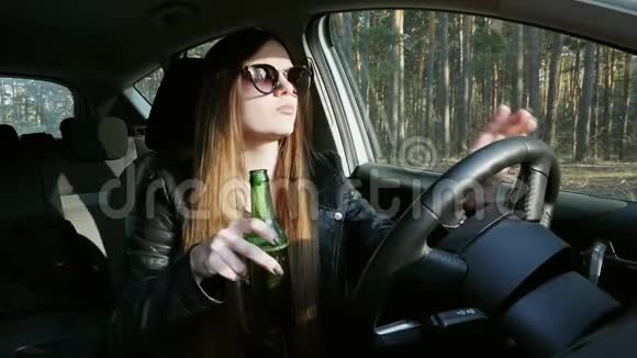 美丽的醉姑娘在车后喝啤酒在车里跳舞视频的预览图