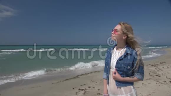 年轻性感的女人穿着白色透明的裙子白发在风中飞扬享受着海边的阳光视频的预览图