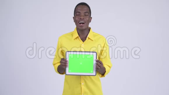 年轻快乐的非洲商人展示数字平板电脑看上去很惊讶视频的预览图