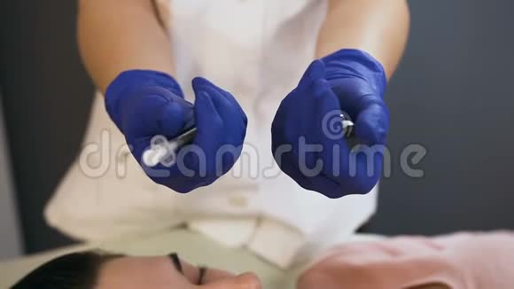 一只手拿安瓿另一只手拿注射器的女性美容师视频的预览图