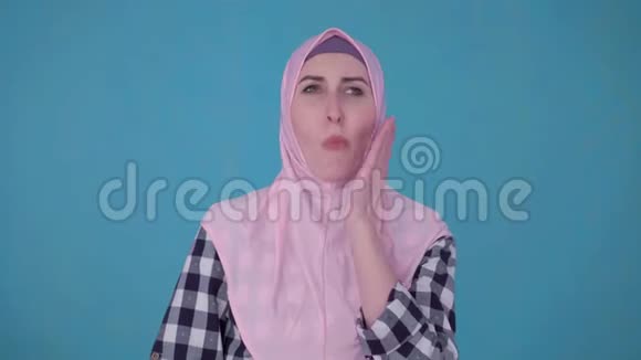 年轻美丽的穆斯林妇女遭受严重牙痛的画像视频的预览图