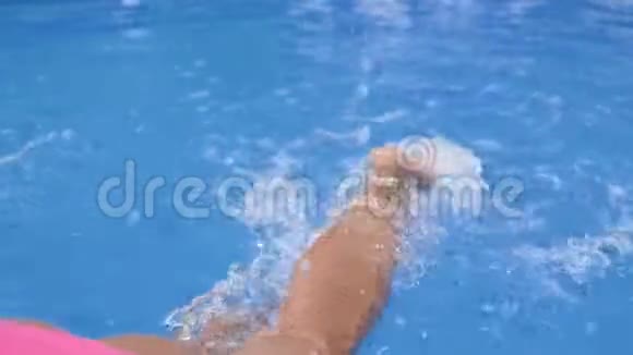 女性美丽的双腿在蓝色清澈的水中挣扎视频的预览图