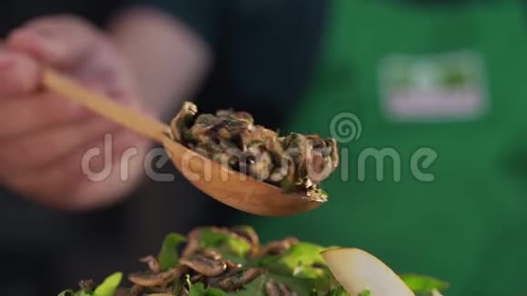 厨师在蔬菜沙拉中加入油炸蘑菇烹饪素食用蔬菜和蔬菜做菜视频的预览图