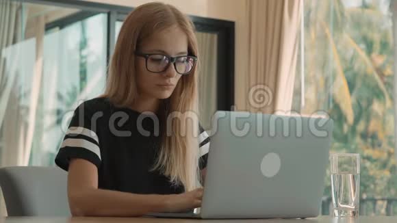 白天女人在公寓的窗户上忙着用笔记本电脑自由职业概念视频的预览图