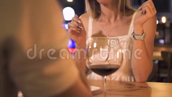 在夜店吃甜点的年轻女子美丽的女人在优雅的餐厅里用玻璃杯喝红酒视频的预览图
