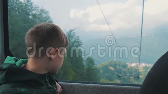 那男孩望着索道的窗户山清水秀山清水秀旅途生活方式视频的预览图
