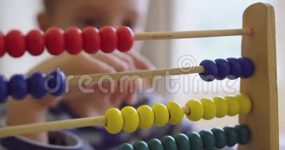 男孩在舒适的家里用算盘学习数学视频的预览图