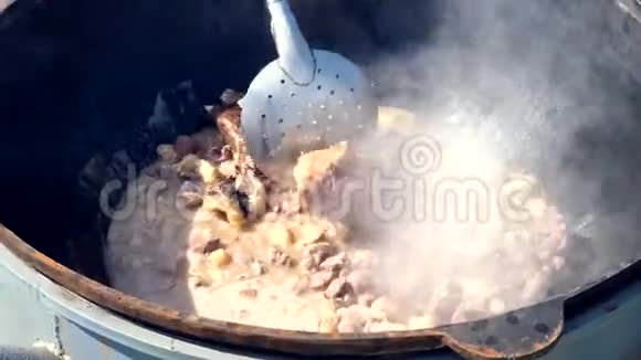 在大锅里用明火在室外做肉饭混合肥肉视频的预览图