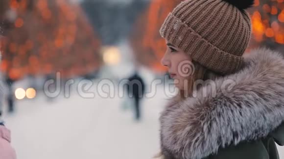 快乐的女性朋友在冬天沿着小巷走视频的预览图