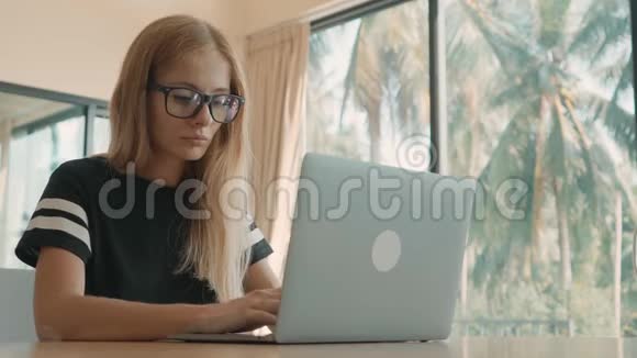 在阳光明媚的日子里笔记本电脑上有金发的女人自由职业概念视频的预览图