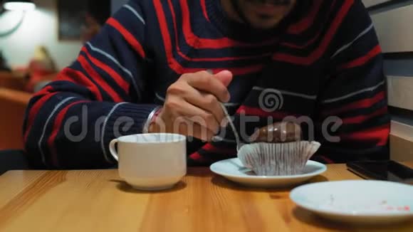 特写一个戴眼镜的印度人在咖啡馆吃巧克力蛋糕视频的预览图