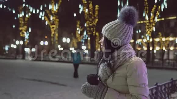 模特穿暖和的衣服咖啡杯在广场上视频的预览图