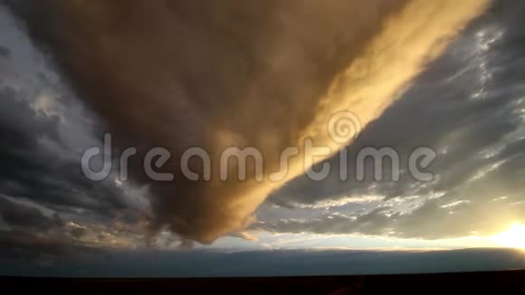 一朵长长的云被夕阳的金光照亮滑过天空视频的预览图