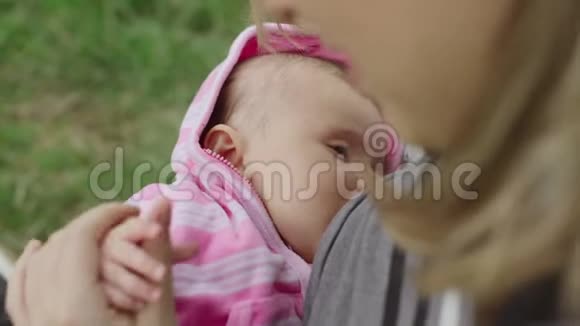 年轻的母亲在户外给她的女婴喂奶视频的预览图