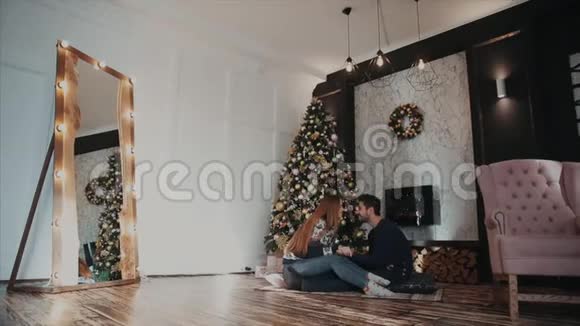 一对夫妇坐在圣诞树对面的总平面图上可爱的谈话视频的预览图
