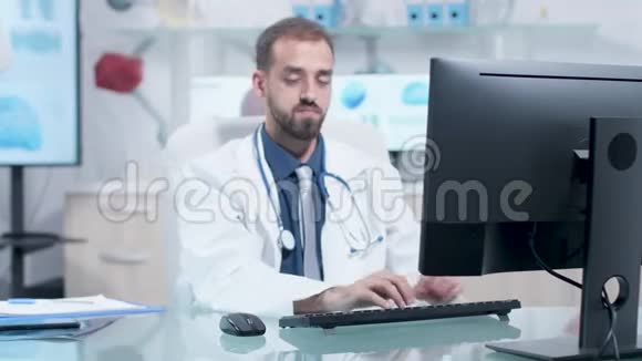 他办公室里疲惫的医生在工作视频的预览图