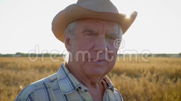 一位戴着牛仔帽的老白种人农民农学家在田野上的肖像视频的预览图