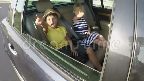 男孩和女孩坐在汽车后座上视频的预览图