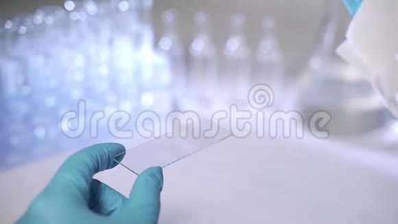 一位科学家正在准备显微镜样品在玻璃滑梯上滴液体化学或遗传研究概念视频的预览图
