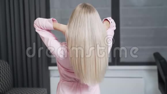 慢镜头拍摄一个年轻女孩的金色长发背面视频的预览图