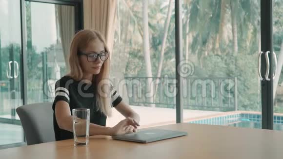 女人在家里打开桌子上的笔记本电脑白天开始打字自由职业概念视频的预览图