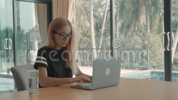 金发女人打字进入电脑关闭它和伸展在她的桌子在家里自由职业概念视频的预览图