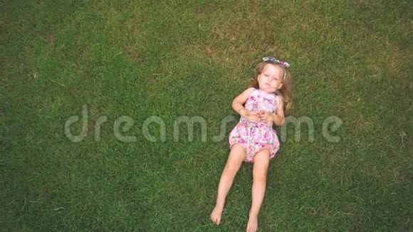 小女孩躺在草坪上视频的预览图