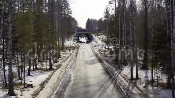 在森林道路上的汽车进入隧道并离开隧道时的鸟瞰图视频的预览图