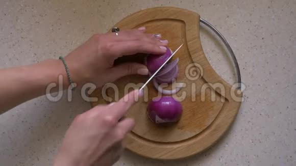 女人在厨房的木板上切红洋葱特写俯视图视频的预览图