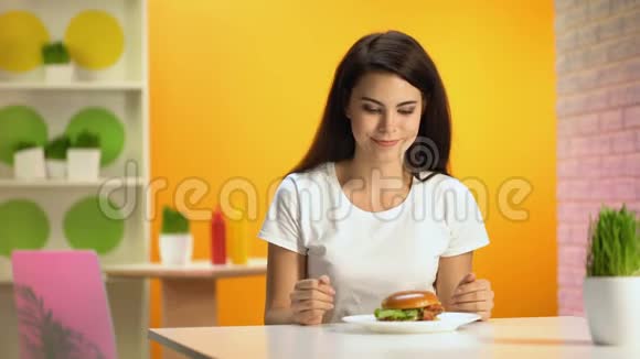 美丽的女性享受美味汉堡的味道在镜头上微笑食欲视频的预览图