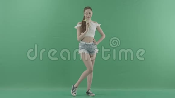 漂亮性感的女人喝绿色背景的鸡尾酒视频的预览图