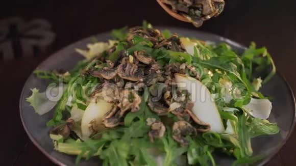 厨师在蔬菜沙拉中加入油炸蘑菇烹饪素食用蔬菜和蔬菜做菜视频的预览图