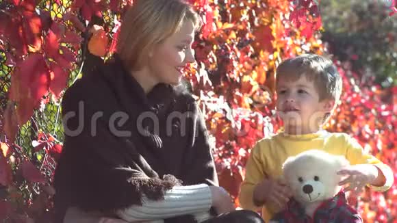 爱家庭快乐的母子户外妈妈和儿子在秋天公园玩玩得很开心母亲和儿童视频的预览图