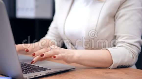 红色指甲的特写女性正在敲击笔记本电脑的键盘视频的预览图