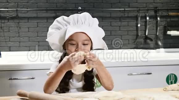 可爱的小女孩在家庭厨房里玩面团面粉和擀面杖在桌子上孩子们表现得像成年人有趣搞笑视频的预览图