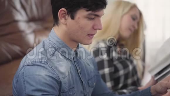 年轻夫妇在家读困难的书一个黑发男人和金发女人讨论材料的肖像视频的预览图