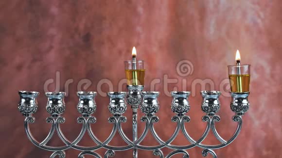 在光明节上点燃第一支蜡烛在燃烧的光明节烛台上点燃第一支蜡烛蜡烛是米诺拉视频的预览图