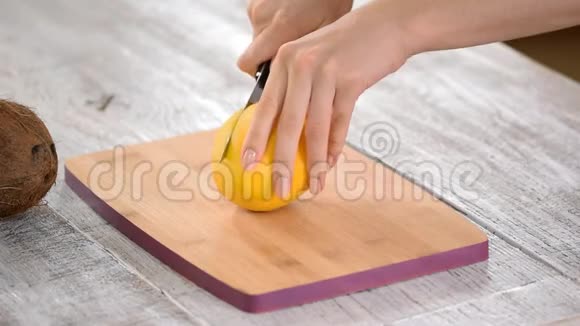 女厨师手在木切板上切芒果视频的预览图