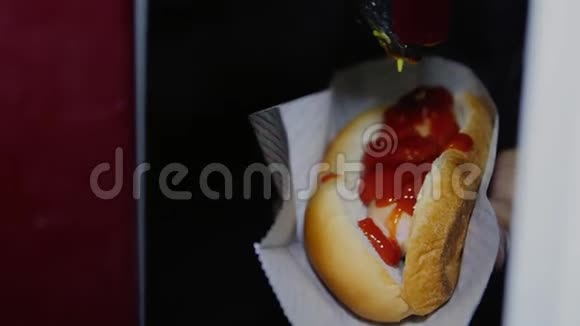 在咖啡馆的特写镜头里把芥末酱加到热狗上视频的预览图