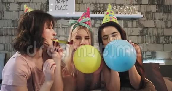 三位有魅力的女士在镜头前用派对装饰在家庆祝生日派对视频的预览图