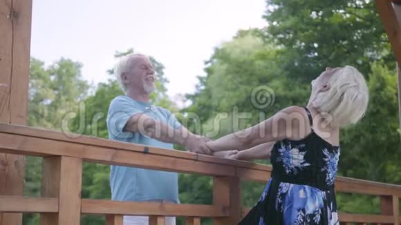 成熟的一对夫妇站在桥上双手捧着说话和微笑穿着夏装的美女视频的预览图
