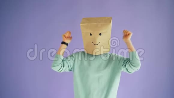 头上戴纸袋的人拇指向上的手势和移动的身体跳舞视频的预览图