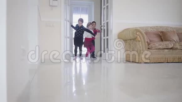 非裔美国男孩和两个女孩在房子里玩三个快乐的孩子打开门跑到大光房里视频的预览图