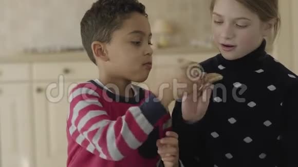 肖像可爱的非裔美国男孩和金发白种人女孩蓝眼睛在厨房玩小朋友视频的预览图
